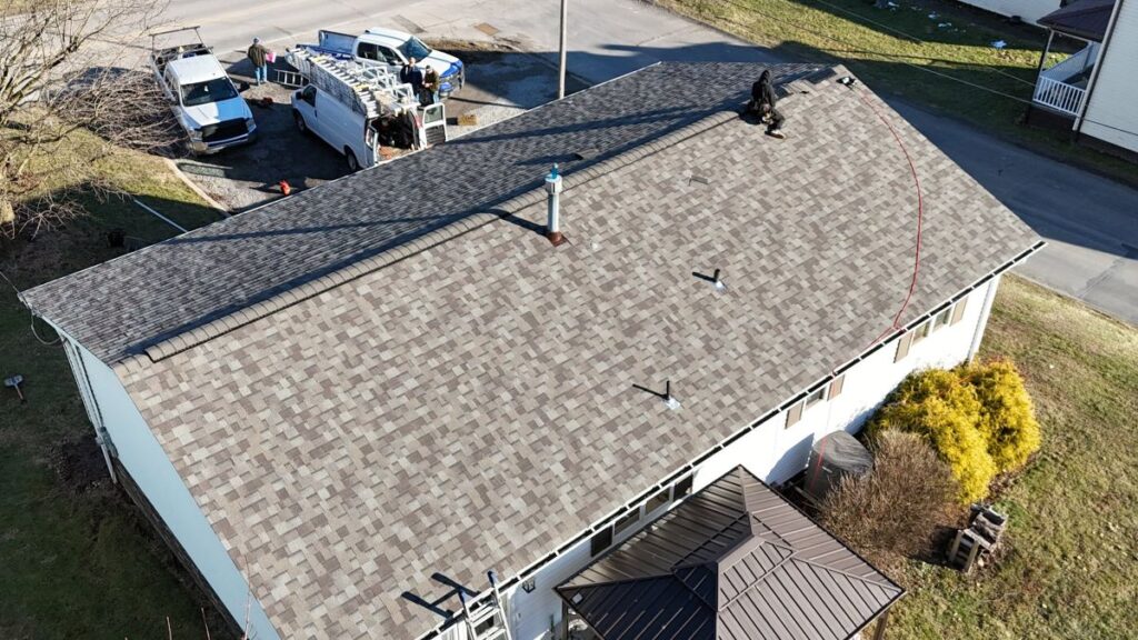 A person works on the sloped roof of a house